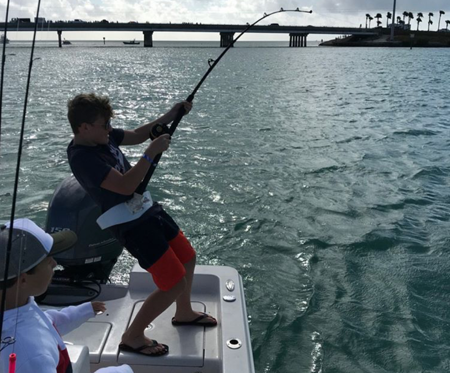 Young man reeling a fish in