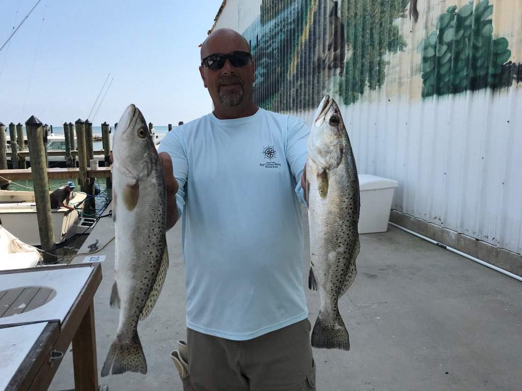 Man holding up two trout